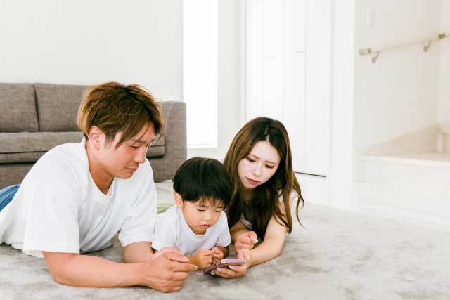 妻と幼い子供がいる若い男性が家族団らん中に住宅ローンの事で悩んでいる様子